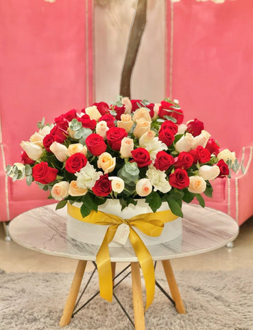 Caja Big Size - 100 Rosas Seleccionadas a Mano - Expresión Perfecta de Amor y Apreciación - Foto de Caja 100 Rosas en Mesa de Mármol con Sillas Rosas en el Fondo